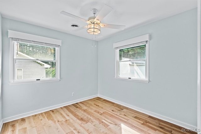 empty room featuring light hardwood / wood-style flooring, ceiling fan, and plenty of natural light