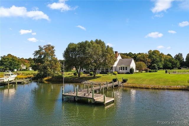 view of dock with a water view and a lawn