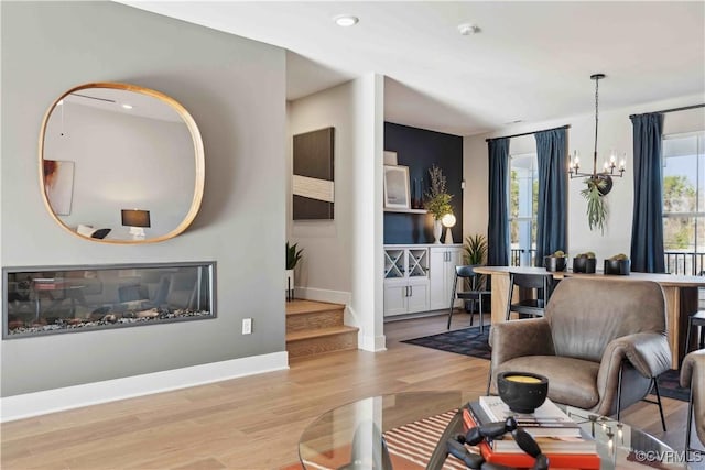 living room featuring light hardwood / wood-style floors and an inviting chandelier