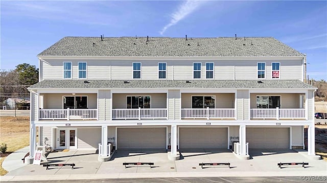 rear view of property with a garage and a balcony