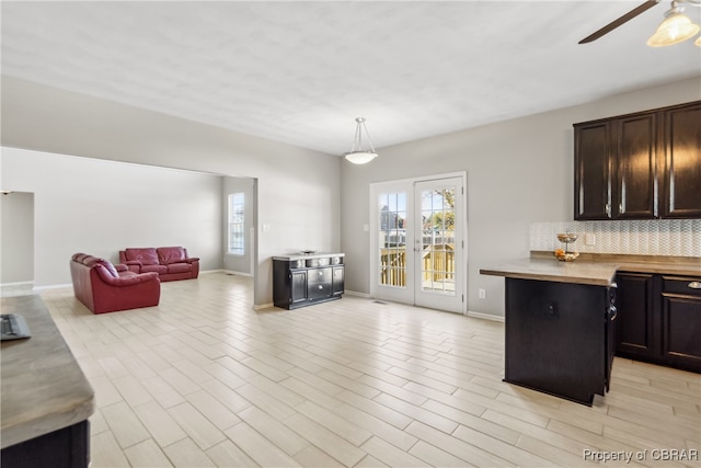 kitchen featuring decorative backsplash, wood counters, decorative light fixtures, light wood-type flooring, and ceiling fan