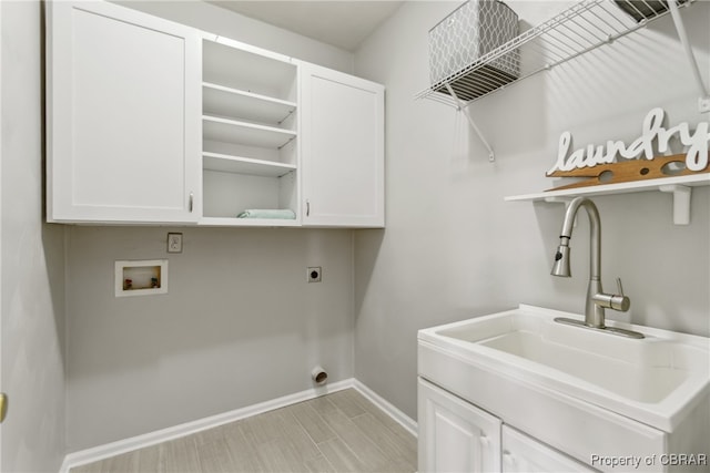 laundry area with hookup for an electric dryer, sink, hookup for a washing machine, and cabinets