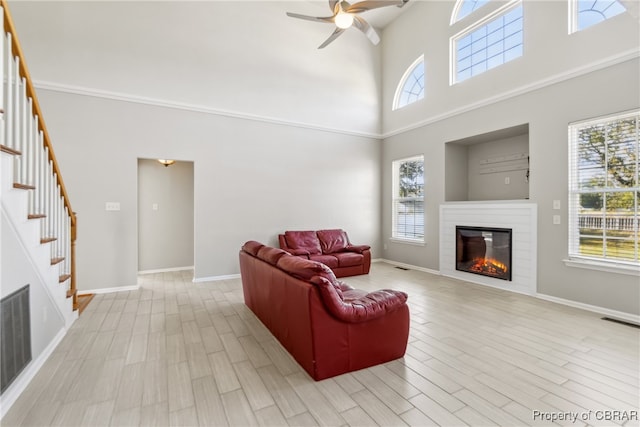 living room with light hardwood / wood-style floors, a high ceiling, and a wealth of natural light