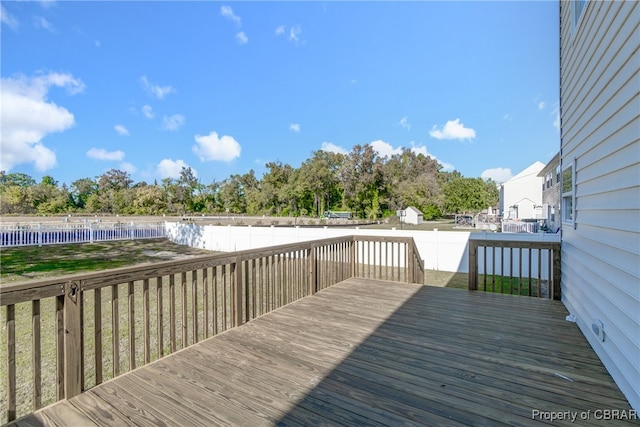 wooden terrace featuring a pool and a yard