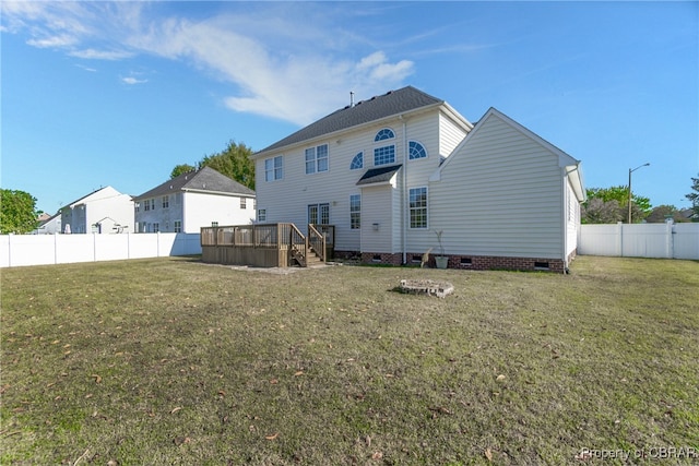 rear view of property featuring a yard and a deck