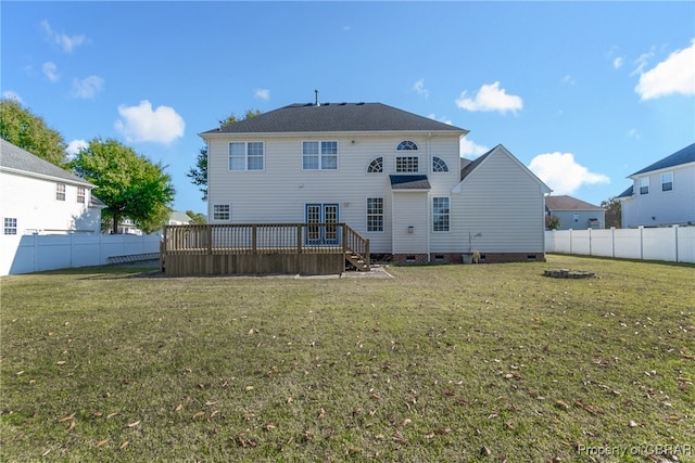 back of house featuring a deck and a lawn