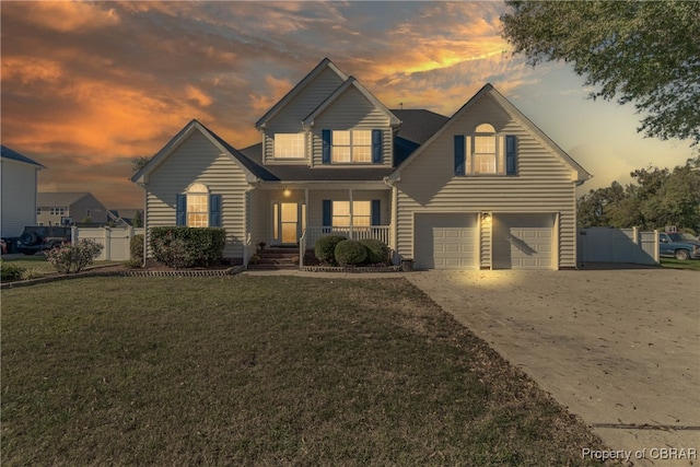 view of front of house with a garage, a lawn, and a porch