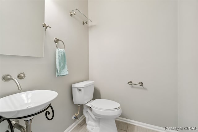 bathroom with sink, hardwood / wood-style flooring, and toilet