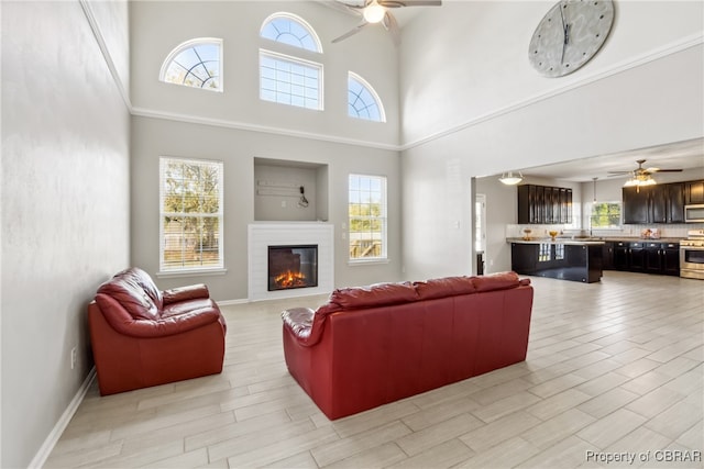 living room featuring a wealth of natural light, light hardwood / wood-style floors, and ceiling fan