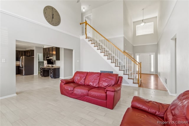 living room with light hardwood / wood-style flooring and a high ceiling