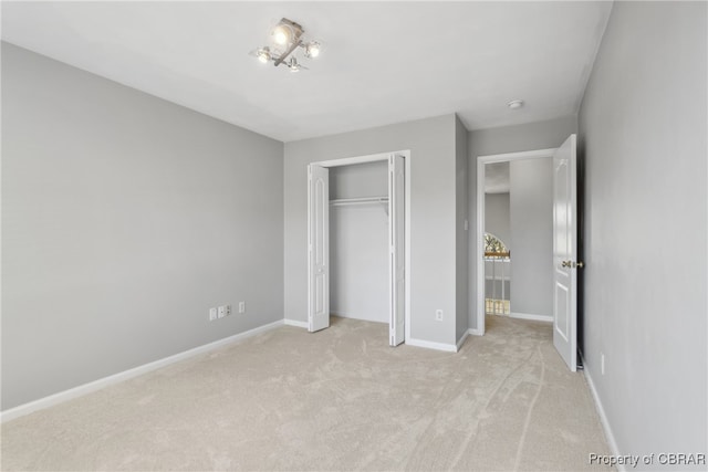 unfurnished bedroom featuring light carpet and a closet