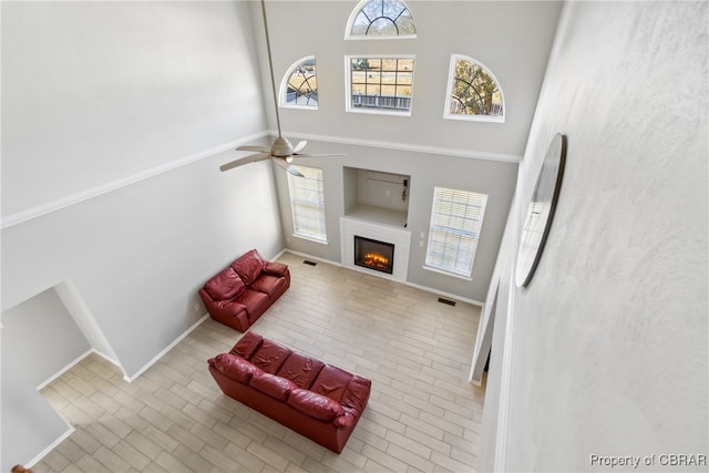 living room with a towering ceiling and ceiling fan