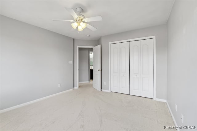 unfurnished bedroom with a closet, light colored carpet, and ceiling fan