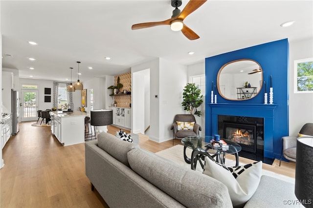 living room featuring ceiling fan and light wood-type flooring