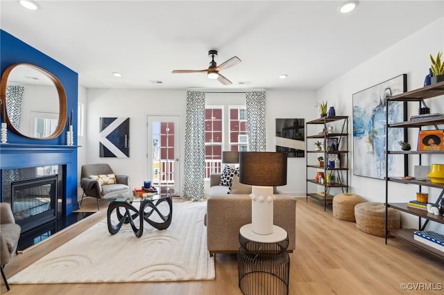 living room with ceiling fan and light hardwood / wood-style floors