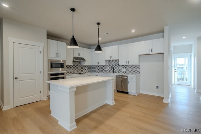 kitchen with appliances with stainless steel finishes, a center island, and white cabinets