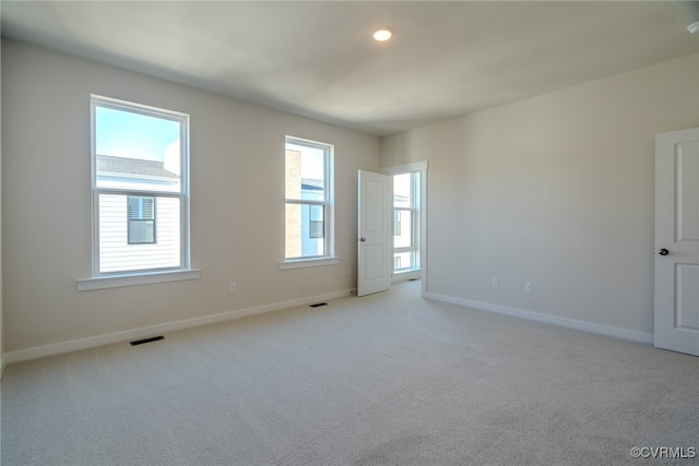 spare room featuring a healthy amount of sunlight and light colored carpet