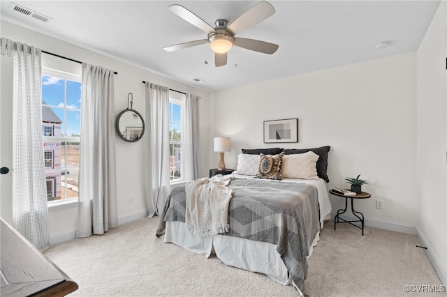 bedroom with ceiling fan and light colored carpet