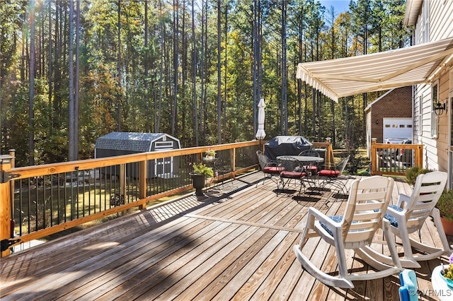 wooden deck with a storage unit and area for grilling