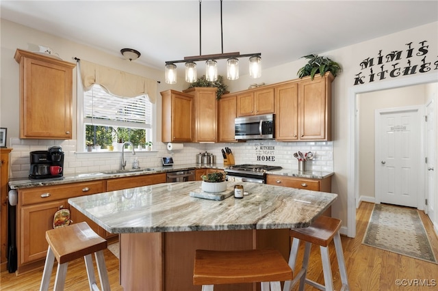 kitchen with tasteful backsplash, stainless steel appliances, sink, and a kitchen island