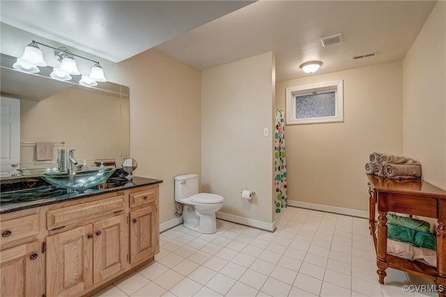 bathroom featuring toilet, a shower with curtain, vanity, and tile patterned floors