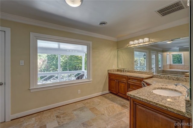 bathroom featuring vanity, a healthy amount of sunlight, and ornamental molding