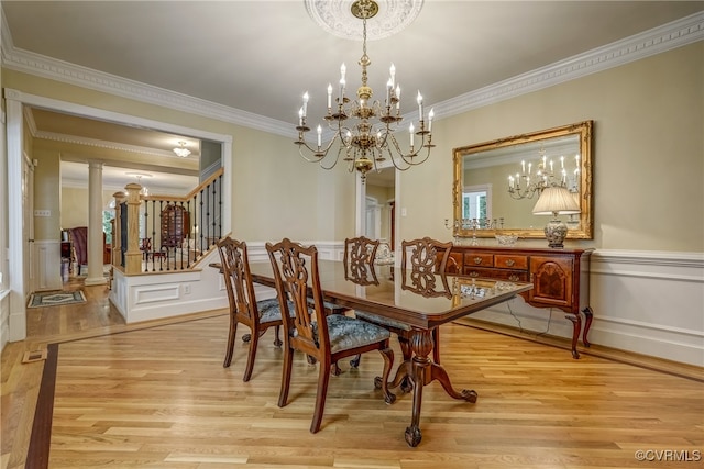 dining space with crown molding, light hardwood / wood-style floors, and decorative columns