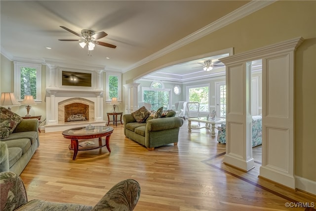 living room featuring ornamental molding, ceiling fan, ornate columns, and light wood-type flooring