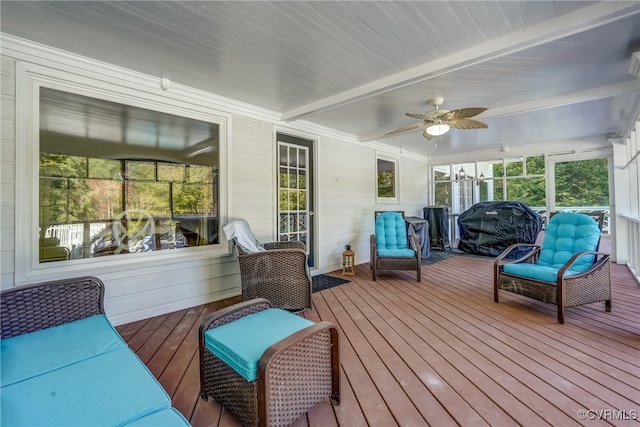 sunroom / solarium featuring beam ceiling and ceiling fan