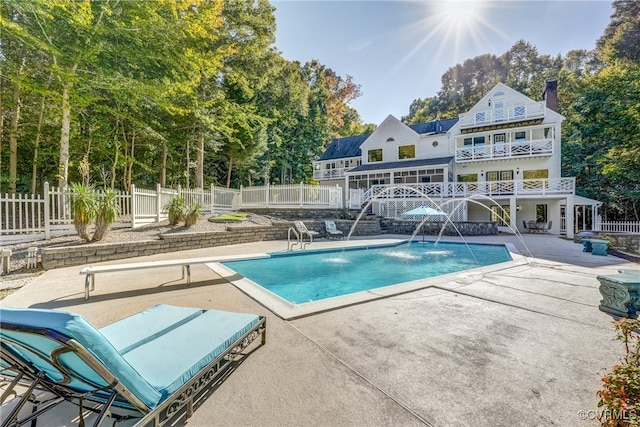 view of swimming pool with pool water feature, a diving board, and a patio