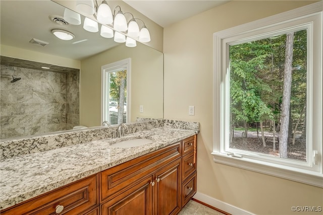 bathroom featuring vanity, tiled shower, and tile patterned floors