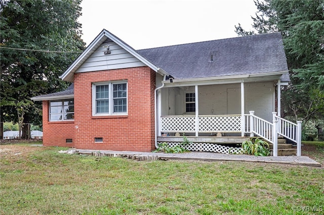 rear view of house featuring a lawn and a porch