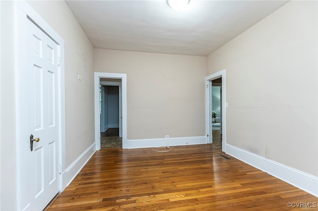 unfurnished room with dark wood-type flooring