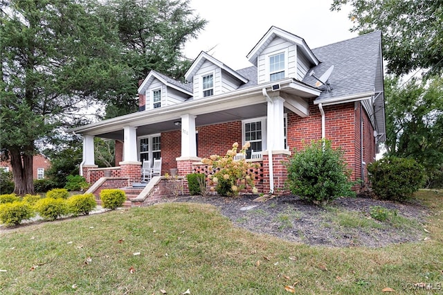 cape cod-style house featuring a porch and a front lawn