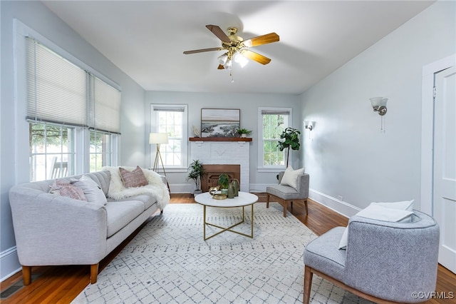 living room with hardwood / wood-style flooring, a fireplace, and ceiling fan