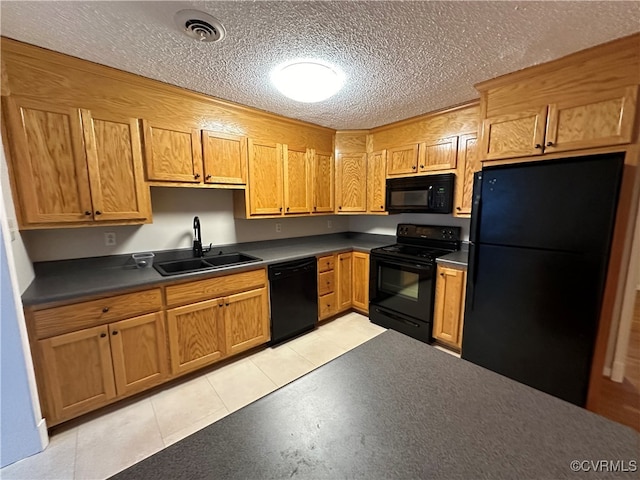 kitchen featuring black appliances, light tile patterned flooring, and sink