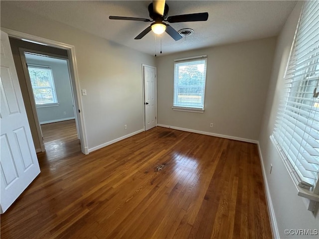 empty room featuring dark wood-type flooring and ceiling fan