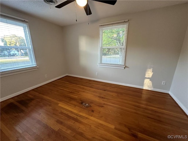 spare room with dark hardwood / wood-style flooring and ceiling fan