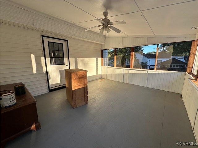 unfurnished sunroom with ceiling fan