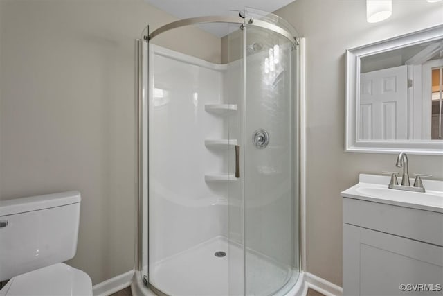 bathroom featuring vanity, toilet, and an enclosed shower