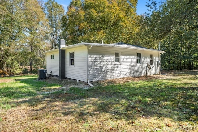 view of outdoor structure with a yard and central AC