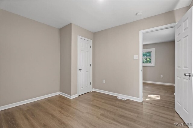 unfurnished room with wood-type flooring