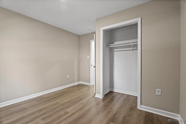 unfurnished bedroom with a closet and hardwood / wood-style flooring