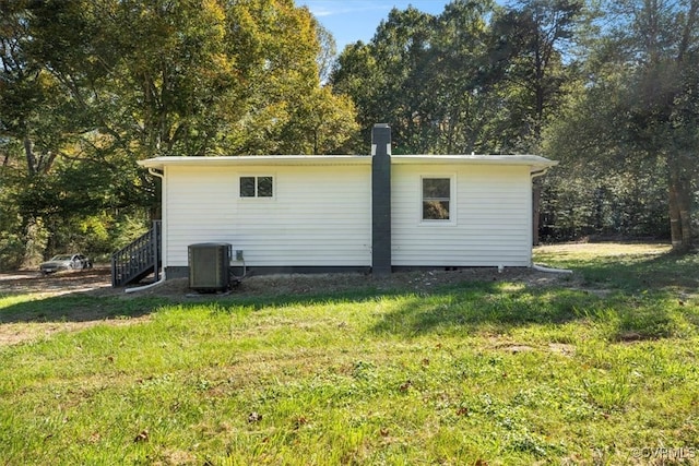 view of outdoor structure with central air condition unit and a yard