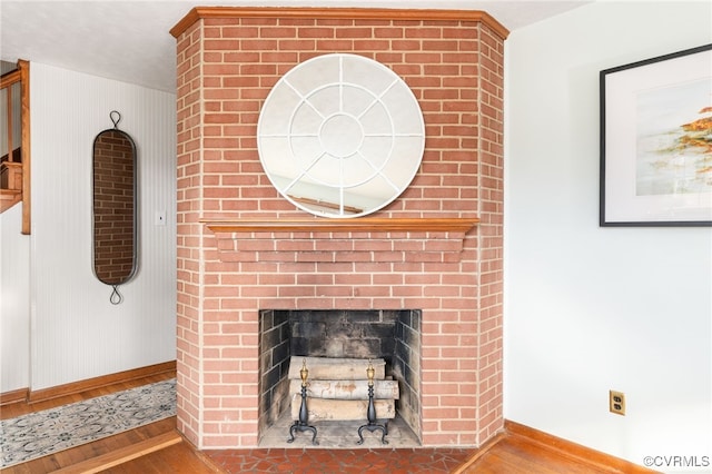 details with hardwood / wood-style flooring and a fireplace