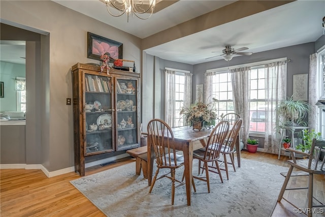 dining area featuring hardwood / wood-style floors and ceiling fan with notable chandelier