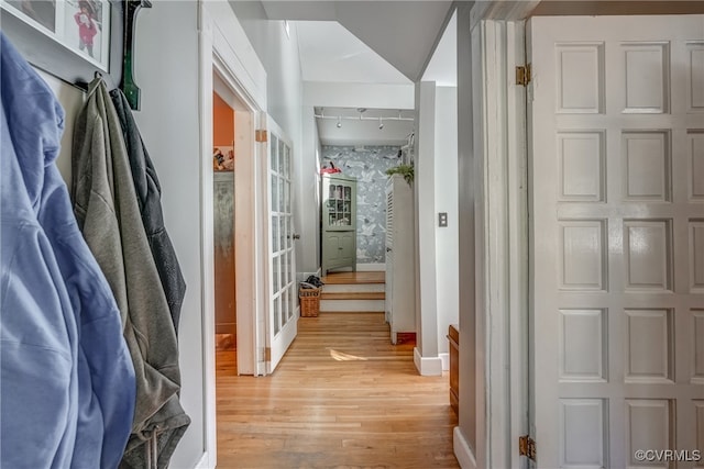 corridor with rail lighting and light wood-type flooring