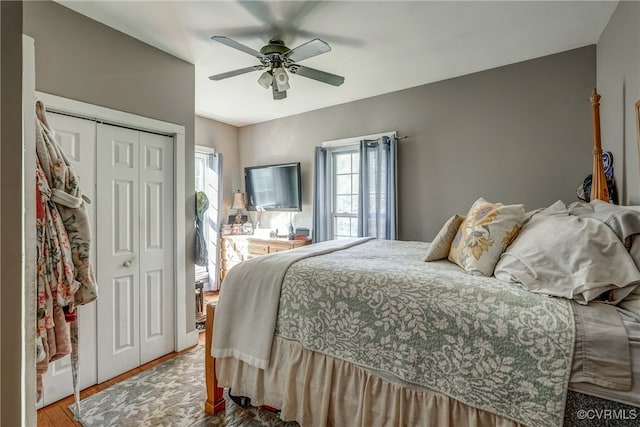 bedroom with a closet, hardwood / wood-style flooring, and ceiling fan