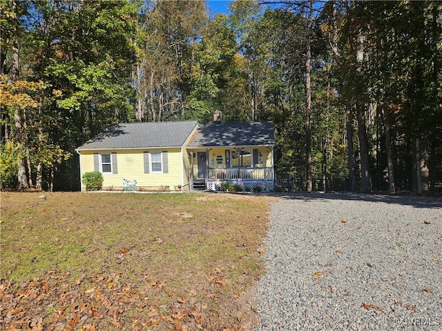 ranch-style home featuring a front lawn and covered porch