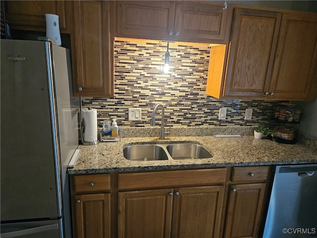 kitchen featuring sink, appliances with stainless steel finishes, decorative backsplash, and stone countertops